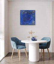 Neoliberal Earth exploitation - Heart Art Original - on light grey wall in dining space with white dining table and two blue chairs