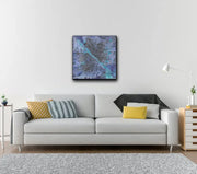  Framed Milky Way Galaxy hanging on light grey wall In room with light grey couch, 1 side lamp, 2 side tables