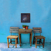 The Earth’s Origins - a Big Bang  - on sky blue wall with small wooden table and two wooden chairs